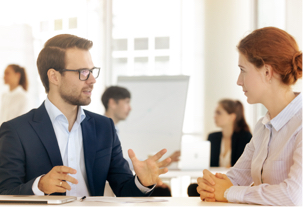 A professional man and woman in conversation while sitting in the Express Scripts Canada office