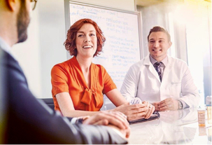 Des membres d’un groupe de professionnels souriants sont assis dans une salle de réunion à Express Scripts Canada.