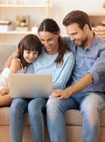 Trois membres d’une famille sont assis sur un canapé et consultent la section sur la réduction des coûts du site Web d'Express Scripts Canada.