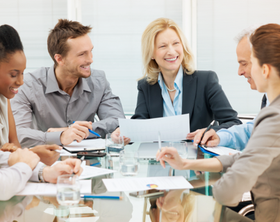 A group of professionals sharing a laugh while sitting around an Express Scripts Canada boardroom table