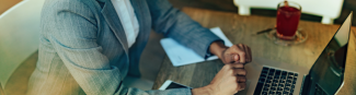 Un homme assis à un bureau travaille à l'ordinateur.