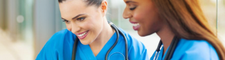 An image of two young female physicians lookDeux jeunes femmes médecin regardent un produit offert par Express Scripts Canada.ing down at an Express Scripts Canada product