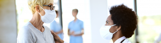 Two masked females in a conversation in a medical clinic