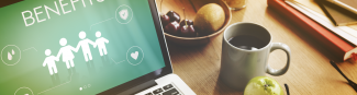 A desk with an open laptop on a page about health benefits, a mug filled with coffee, an apple and bowl of fruit.