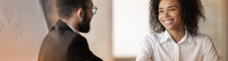 A young black woman smiling and shaking hands with an Express Scripts Canada employee