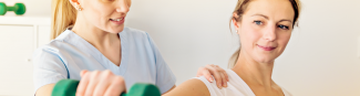 A young female physician checking a female patient's shoulder