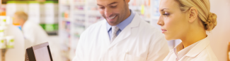 Two Express Scripts Canada pharmacists looking at group benefits on a laptop screen