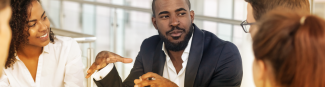 A young black male leading a group discussion at Express Scripts Canada