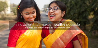 A joyful Indian mother and daughter dressed in traditional attire laughing together